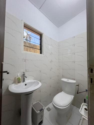 a white bathroom with a toilet and a sink at Villa Mondoukou Beach in Île Bouët