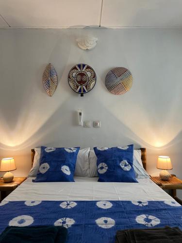 a bedroom with a blue bed with blue pillows at Villa Mondoukou Beach in Île Bouët