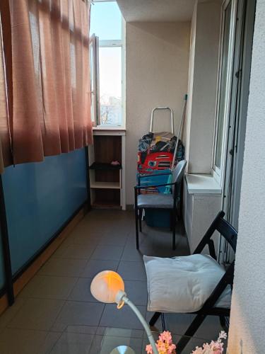 a room with a bed and a chair with a suitcase at Kawalerka in Gdynia