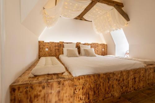a bedroom with a wooden bed with white sheets at Château des Salettes in Anoye