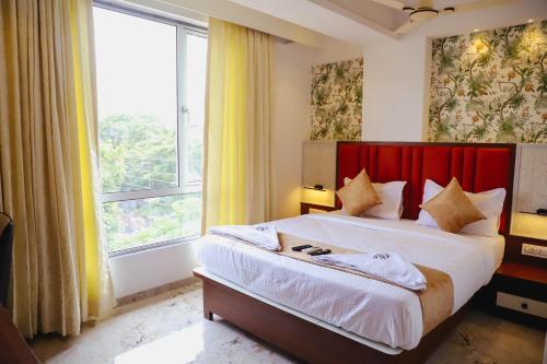 a bedroom with a large bed with a red headboard at Sapphire Suites in Navi Mumbai