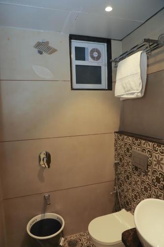 a bathroom with a toilet and a sink at Sapphire Suites in Navi Mumbai