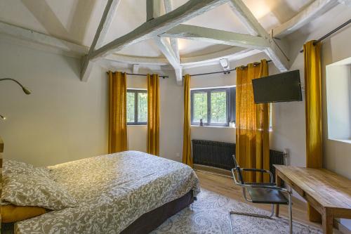 a bedroom with a bed and a desk and windows at Lodge de Loire - B & B proche Chambord in Saint Laurent Nouan