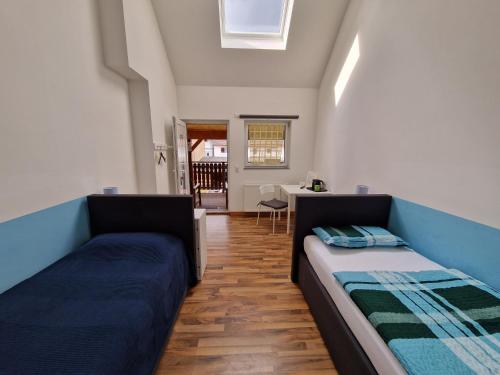 a room with two beds and a dining room with a table at Pension Assenheim in Assenheim