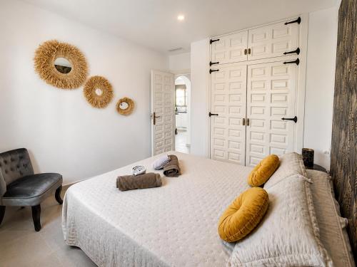 a bedroom with a large white bed and a chair at Casa Etxetxoa - Calpe in Ifach