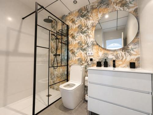 a bathroom with a toilet and a mirror at Casa Etxetxoa - Calpe in Ifach