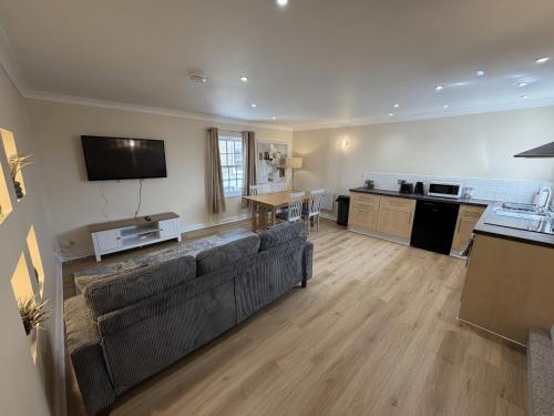 a living room with a couch and a kitchen at Ely Stays City Center 2 Bedroom Flat in Ely