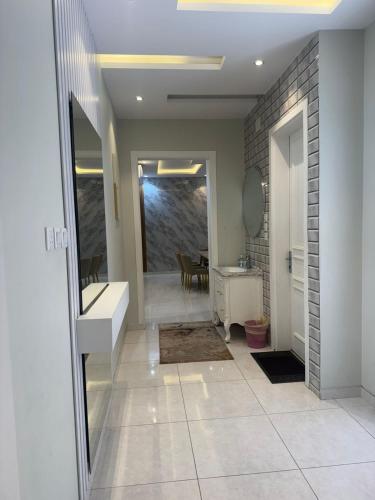 a hallway with a bathroom with a sink and a table at دور فخم كامل 6 غرف بحوش خاص ومدخل سيارة in Taif