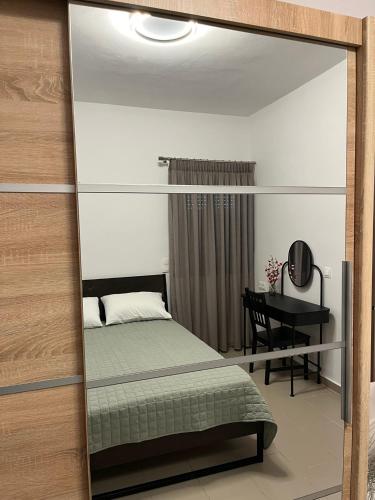 a mirror in a bedroom with a bed and a desk at Nenes Comfort Apartment in Koroni