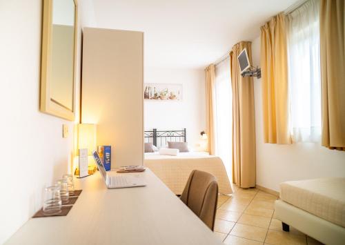 ein Zimmer mit zwei Betten und einem Schreibtisch mit Laptop in der Unterkunft Hotel Sylesia in Letojanni