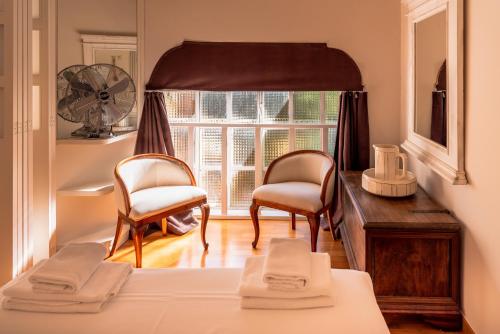 a bedroom with a bed and two chairs and a window at La Limonaia - Tremezzo by LoveComo in Tremezzo