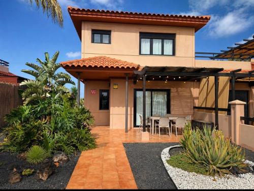 a house with a patio with a table and chairs at Villa Twins in Lajares