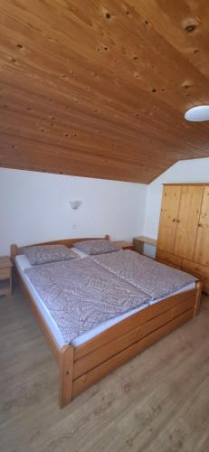 a bed in a room with a wooden ceiling at Rooms-Apartment Renata in Bled