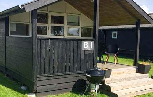 a house with a grill and a b on the porch at Nice Apartment In Farsø With Heated Swimming Pool in Farsø