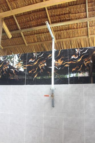a pole in a bathroom with a black and brown stripe on the wall at Cucu Suzanne in Lasikin