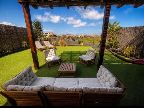 a patio with a couch and chairs and a hammock at Villa Twins in Lajares