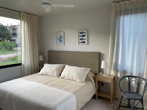 a bedroom with a bed and a window at Casa Cortaderas, Barrio Quequén Chico in Necochea