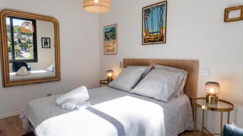 a bedroom with a white bed and a mirror at Lis Oureto in Saint-Cyr-sur-Mer