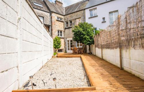 an internal courtyard of an old building with a wooden walkway at Agréable Jardin Et Terrasse in Sourdeval