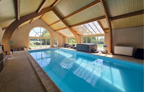 an indoor swimming pool with a large ceiling at Gite En Campagne in Avezé