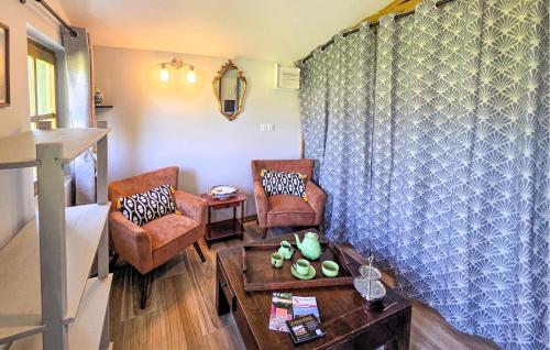 a living room with two chairs and a table at Gite En Campagne in Avezé