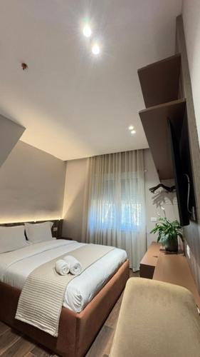 a bedroom with a bed with two towels on it at Elios Near Centre Apartment in Tirana