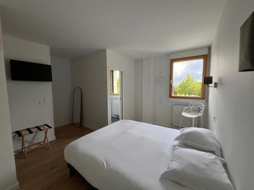 a bedroom with a large white bed and a window at Brit Hotel L'Arrivée Guingamp in Guingamp