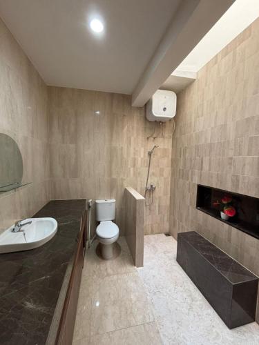 a bathroom with a toilet and a sink and a fireplace at Base Seven Hostel in Bandung