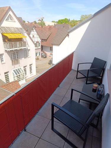 a patio with two chairs and a table on a balcony at Herzstück in Gengenbach