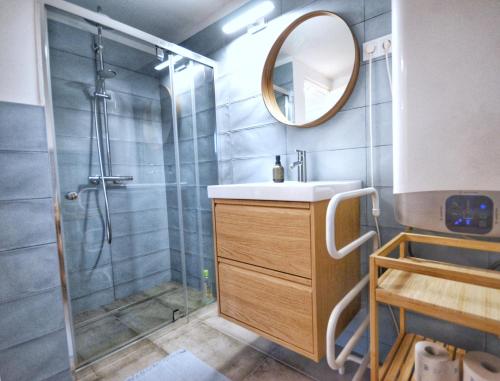 a bathroom with a shower and a sink and a mirror at Aranyos Házikó in Nagymaros