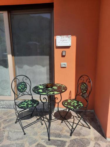 a table and two chairs sitting next to a wall at La Rosa di Emma in Porlezza