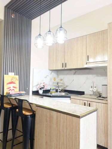 a kitchen with a counter and some chairs and lights at Avida Aspira Studio 18th in Cagayan de Oro