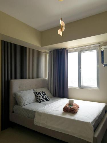a bedroom with a large bed with a window at Avida Aspira Studio 18th in Cagayan de Oro