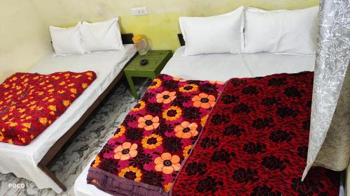 two beds in a room with flowers on them at The Kedar Heights in Gupta Kāshi
