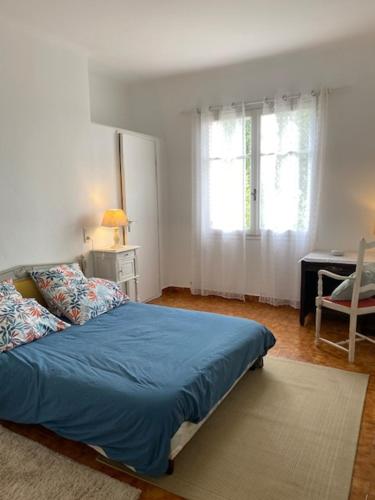 a bedroom with a blue bed and a desk at Le Chêne in Villeneuve