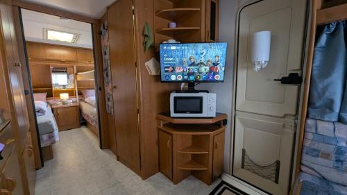 a small room with a tv and a bedroom at Mikael's Bed & Spa - Camping Suite in Sandefjord