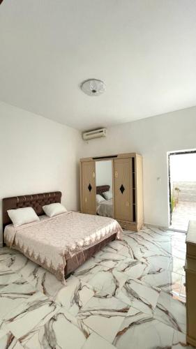 a bedroom with a king sized bed and a mirror at Ain El Turk Beach Apartment in Aïn El Turk