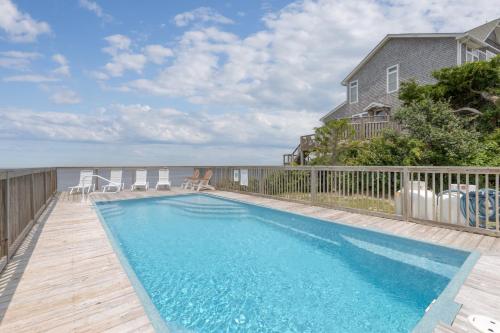 a swimming pool on a deck next to a house at 7815 - Tarhoo in Frisco