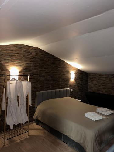 a bedroom with a bed and a brick wall at Love room in La Celle-sous-Gouzon