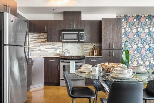 a kitchen with a table with chairs and a refrigerator at Jungle Book Luxe Suite Downtown BMO in Calgary