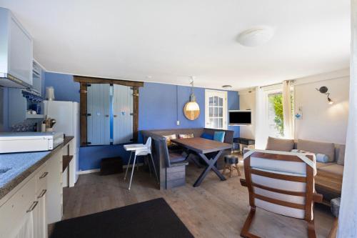 a kitchen and living room with a table and a couch at De Zilverreiger op camping Oudesluis in Oudesluis