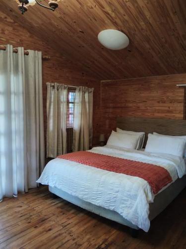 a bedroom with a large bed and a wooden ceiling at Greenstone Guesthouse in Muldersdrift