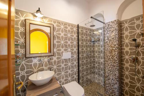 a bathroom with a sink and a toilet and a mirror at Il Giardino Dei Limoni in Praiano