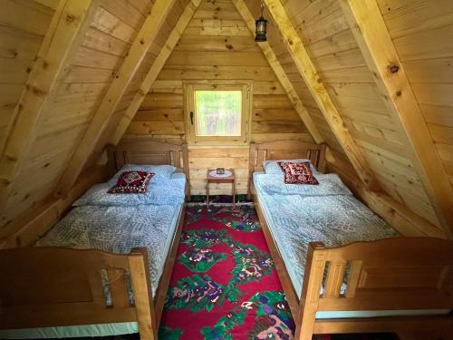 two beds in the attic of a log cabin at Kamp-Seosko Domaćinstvo Dizdarević in Bijelo Polje