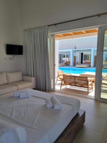a bedroom with a large bed and a pool at Blue Summer Luxury Suites in Kourouta