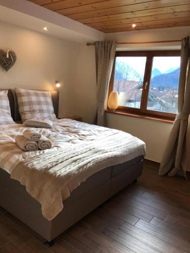 a bedroom with a bed and a large window at BERGSUCHT-Ruhpolding, Traumlage am sonnigen Südhang, kostenlose Parkplätze, schnelles WLAN, ruhige Sackgasse, NETFLIX inklusive in Ruhpolding