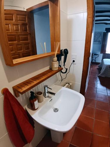 a bathroom with a white sink and a mirror at La Locana in Bubión