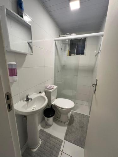 a bathroom with a toilet and a sink and a shower at Apartamento in Campo Largo