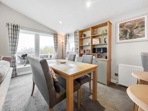 a dining room with a wooden table and chairs at Turnberry Lodge in Girvan