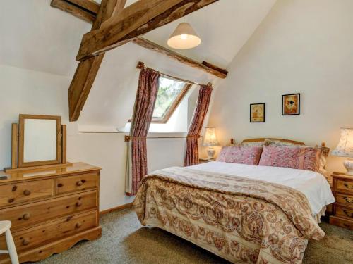 a bedroom with a bed and a dresser and a window at Bossington- Ukc4921 in Timberscombe
